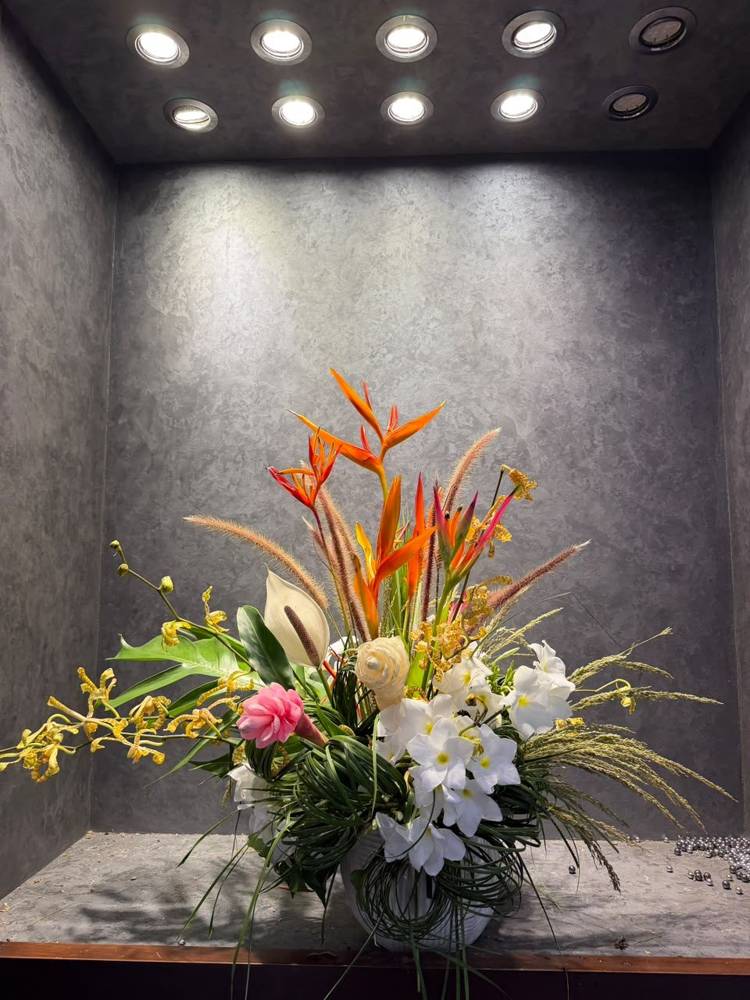 Orange heliconia above white frangipani and pink ginger